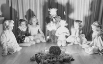 Children sitting in a circle at a Halloween party in 1950.