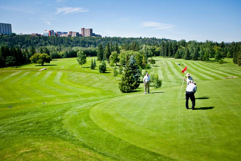 View of golf course with city skyline in the background