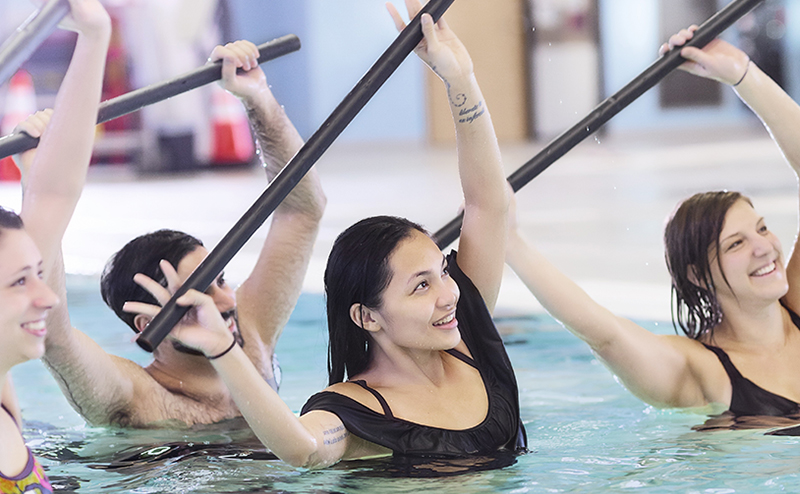 A group of people doing a workout routine in a pool.