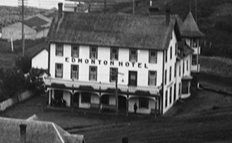 An aerial photo of a white three storey hotel