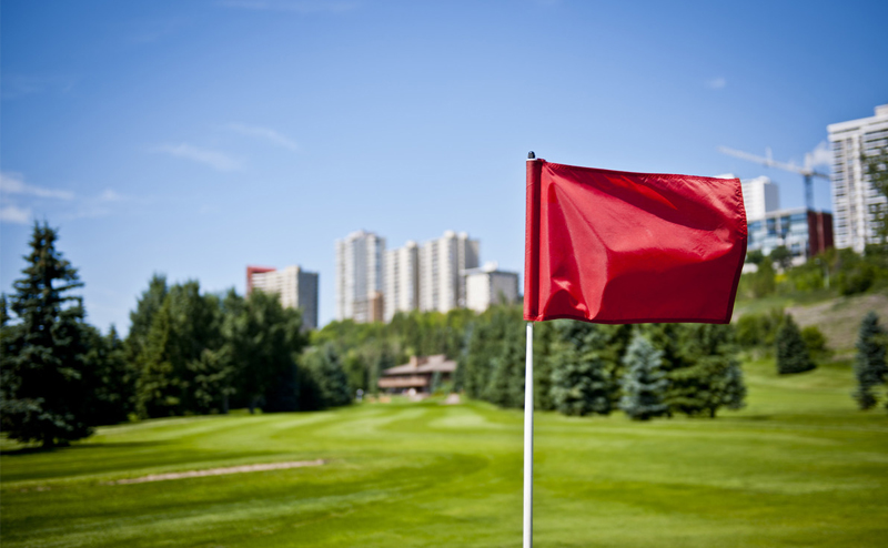 A red golf flag on a golf course.