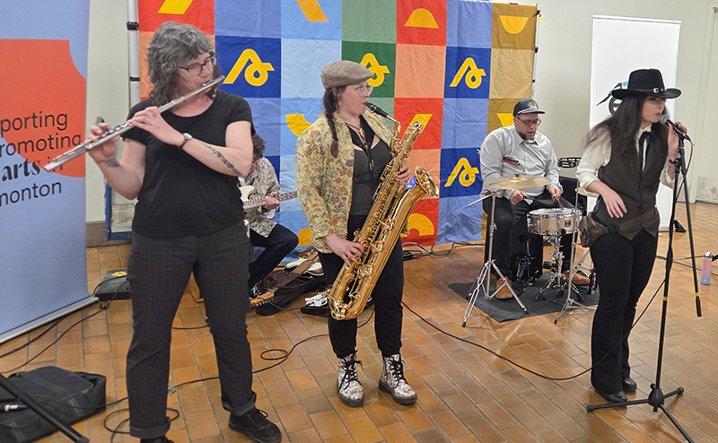 Four person band playing music at LRT station