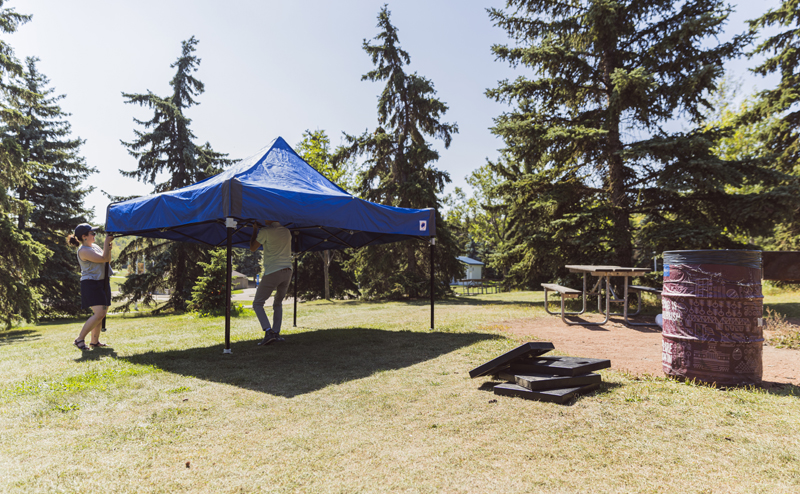 People setting up a tent at a drop-in picnic site
