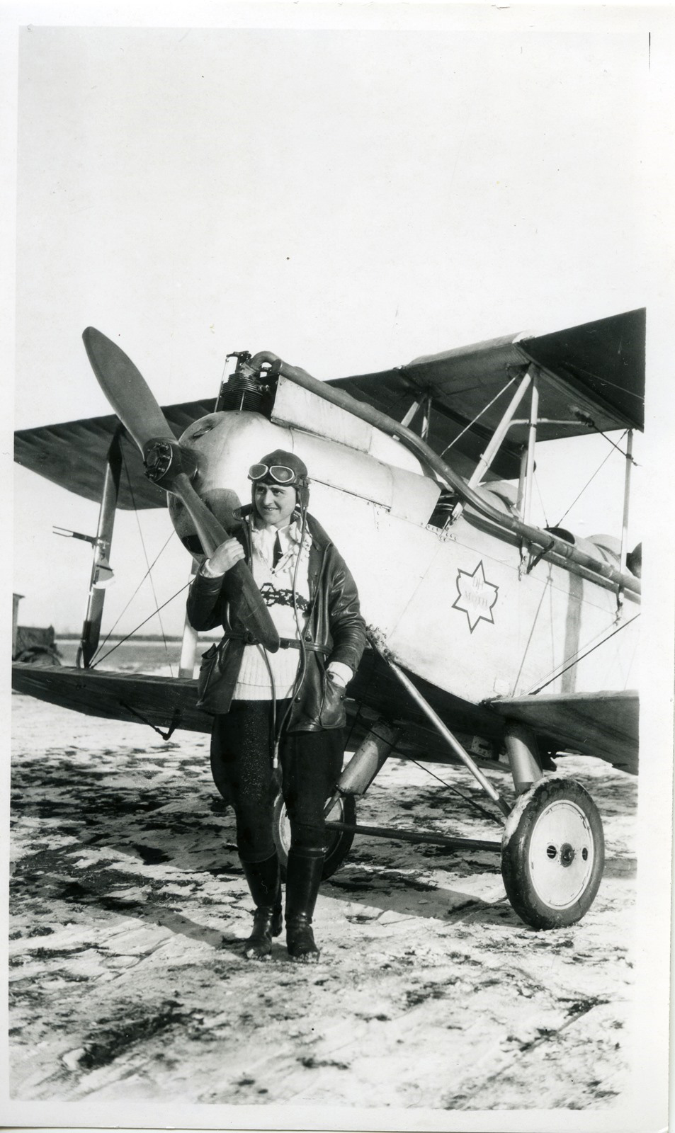 A woman standing in front of 1920s airplane