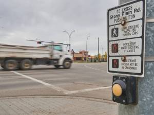 button with sign before crosswalk on road