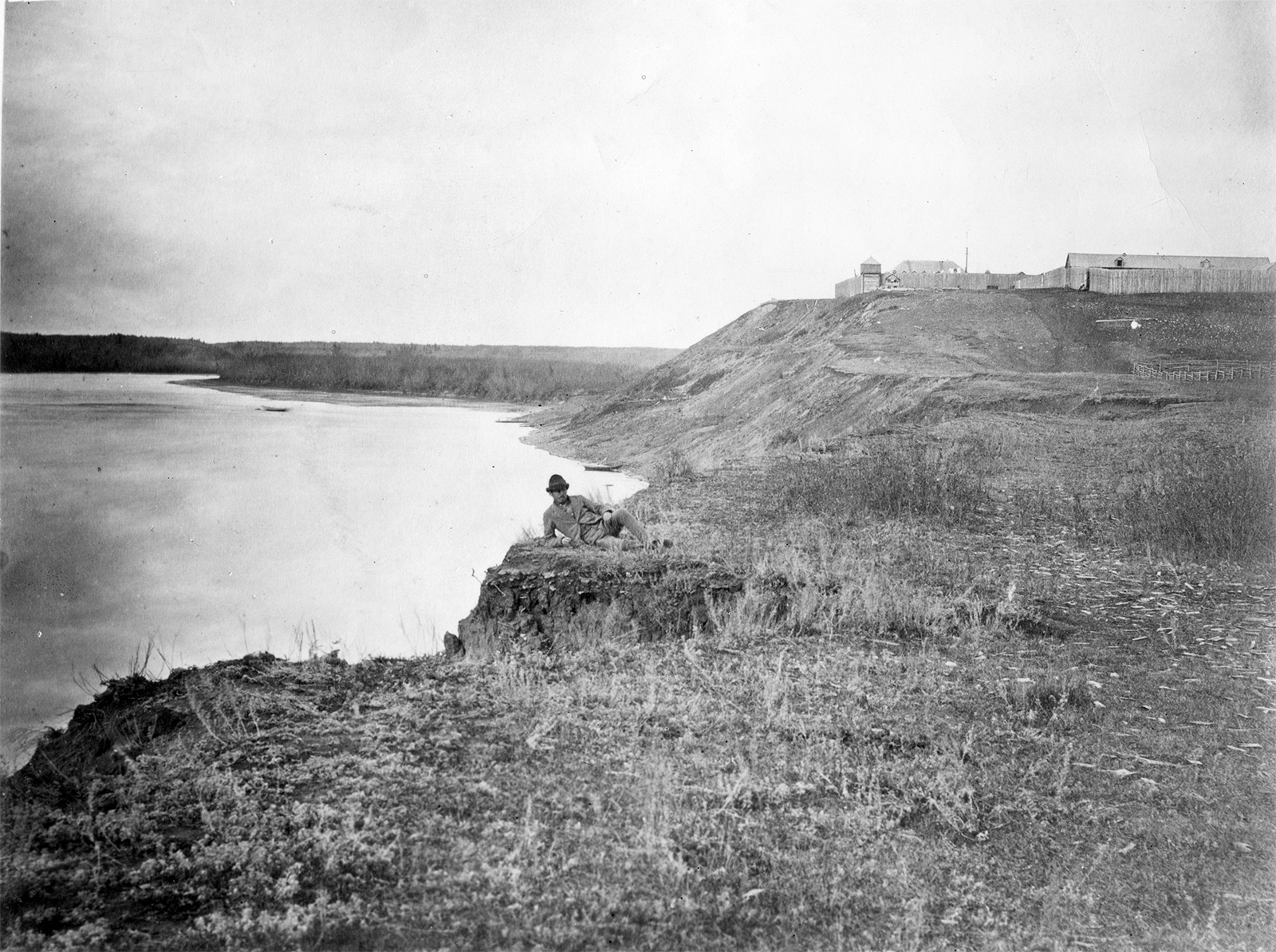 A black and white photo of Fort Edmonton along the North Saskatchewan River.