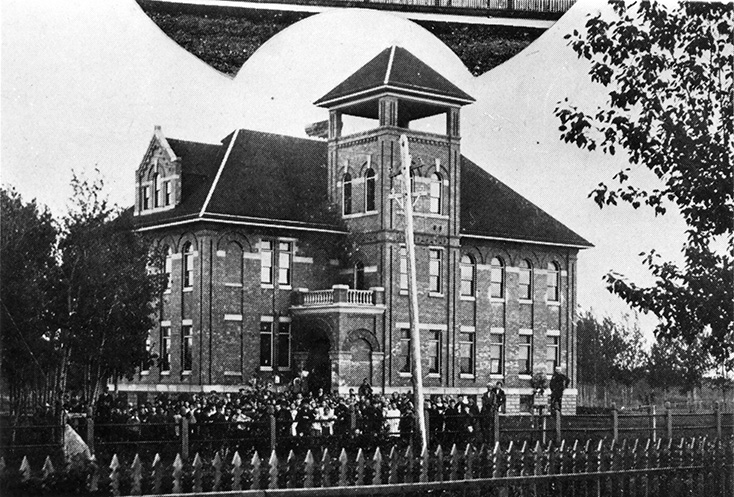A black and white photo of an ornate school.