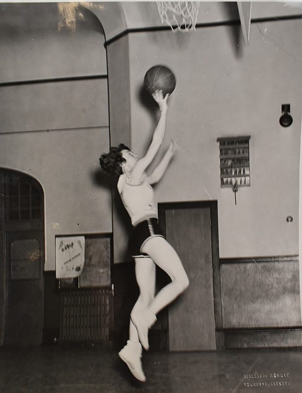 Black and white photo of Etta Dann performing a layup