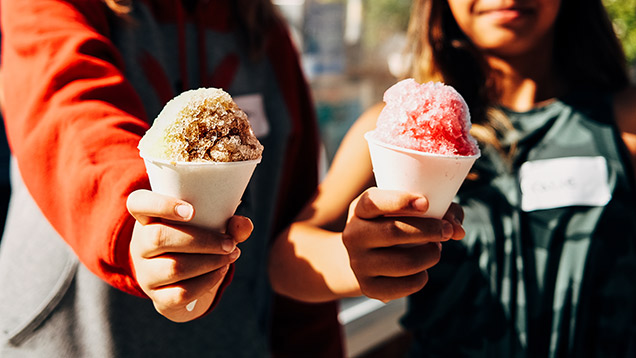 two people holding snowcones