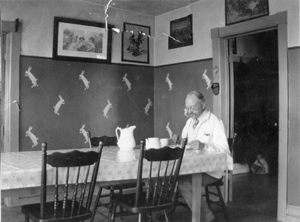 A man sitting at a dining table in an old farmhouse.