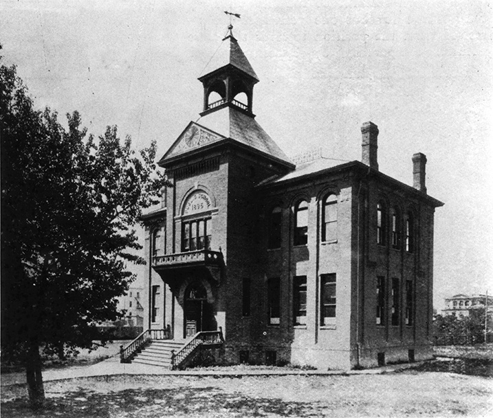 A brick school with a bell tower.