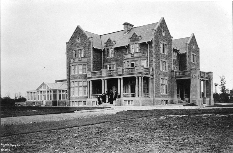 A black and white photo of the Government House: A three storey brick house.