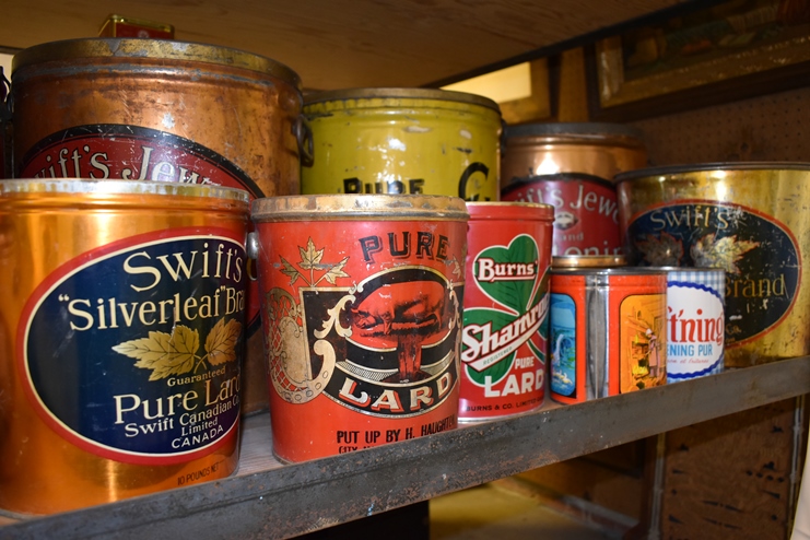A collection of vintage lard tins on a shelf.