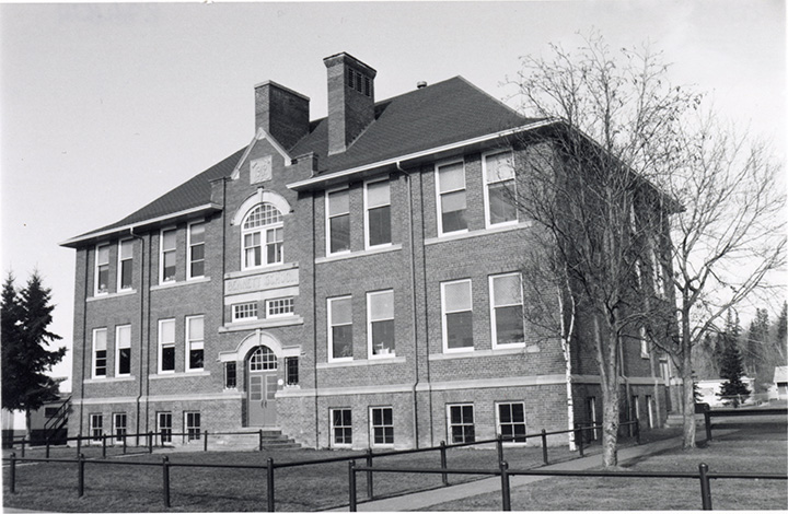 A black and white photograph of a brick school.