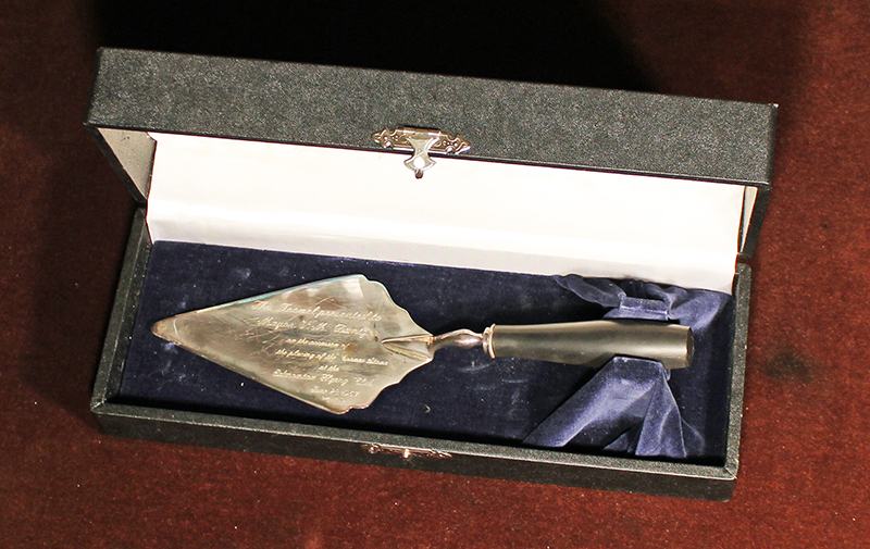 A silver trowel in a black case.