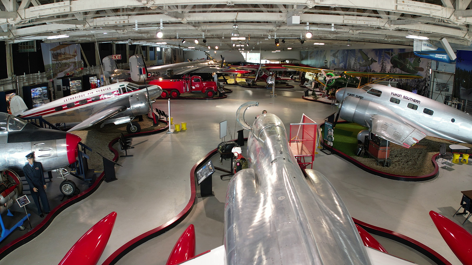 Aircraft and vehicles inside the Alberta Aviation Museum.