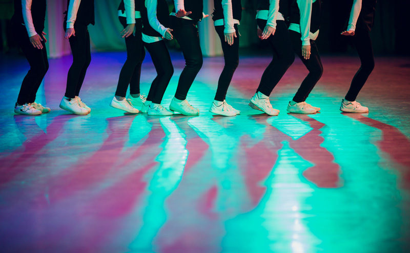Dancers on a stage. The framing of the photo shows only the dancers' legs visible.