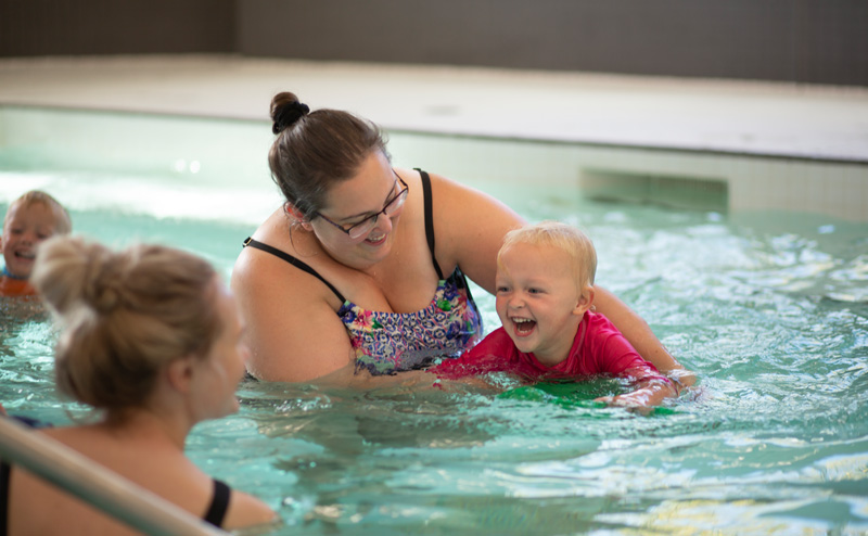 A woman and a child playing in a pool at a City Recreation Centre.