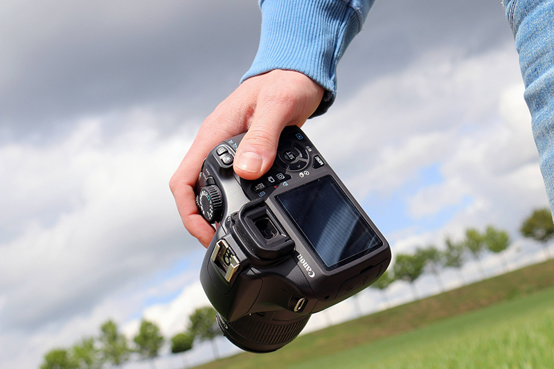 View of a person's hand holding a camera
