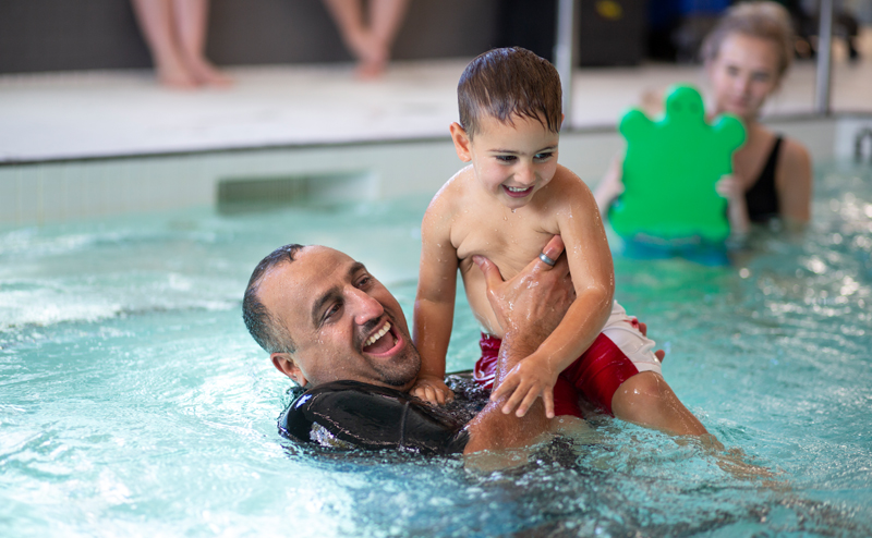 A man playing with a child in a pool.