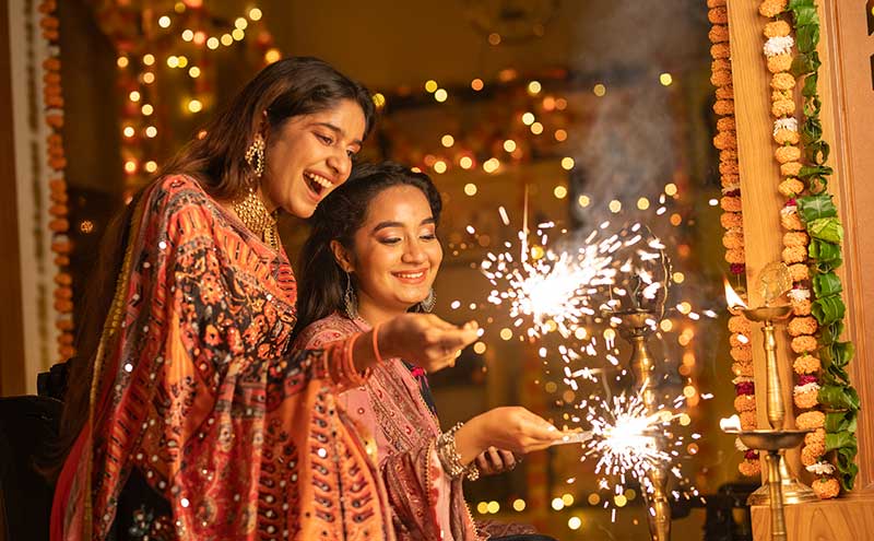 two person burning sparklers at home