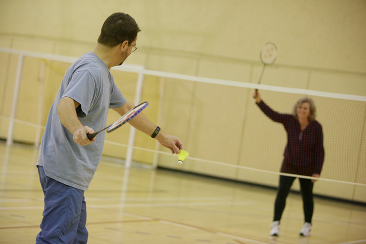 Photo of two people playing badminton.