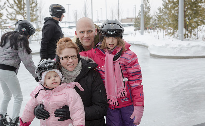 A family skating on an outdoor ice rink.
