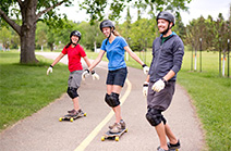 Three people skateboarding down a trail.