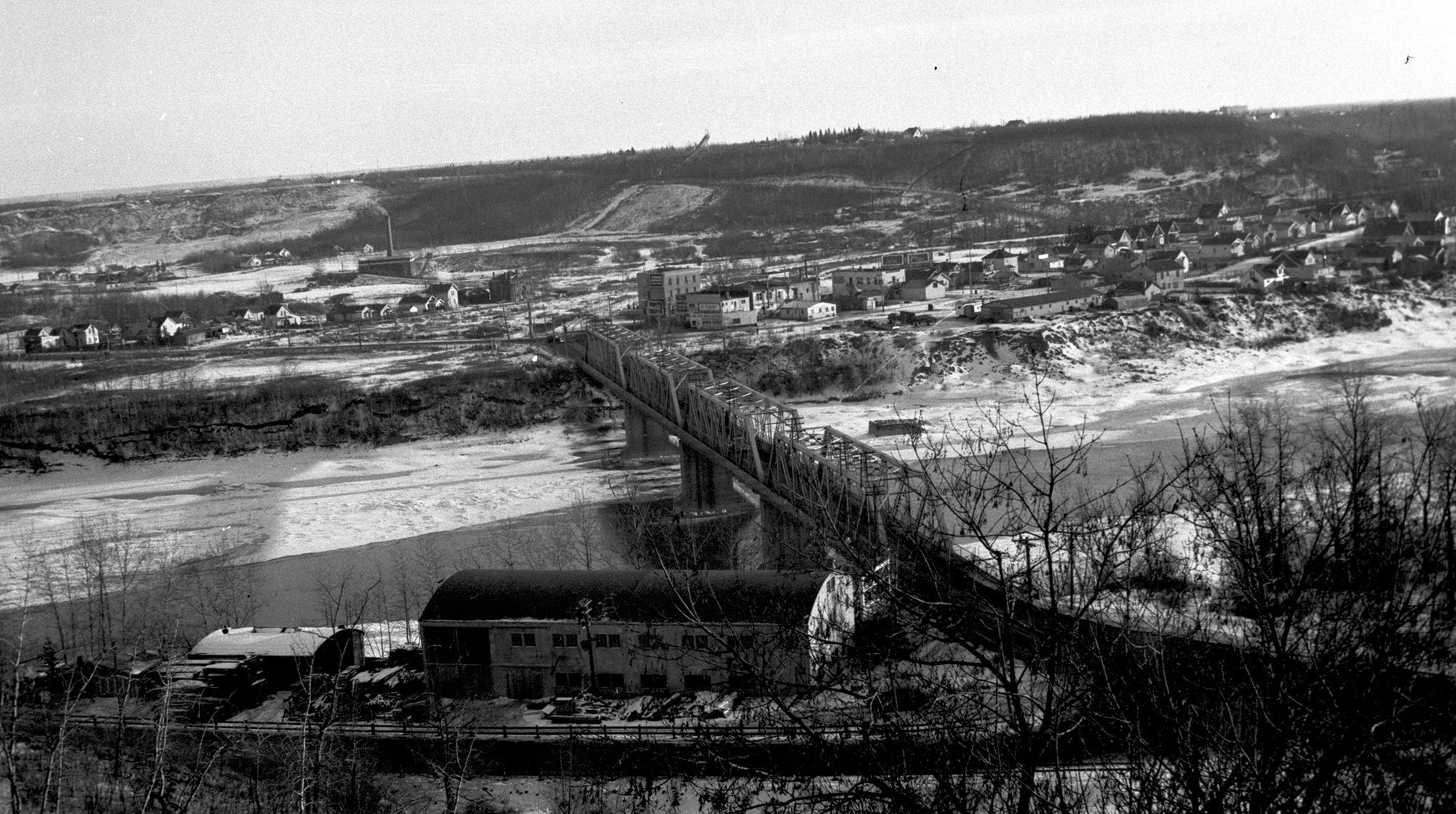An overhead black and white photo of Alberta Motor Boat Co. along the North Saskatchewan River.