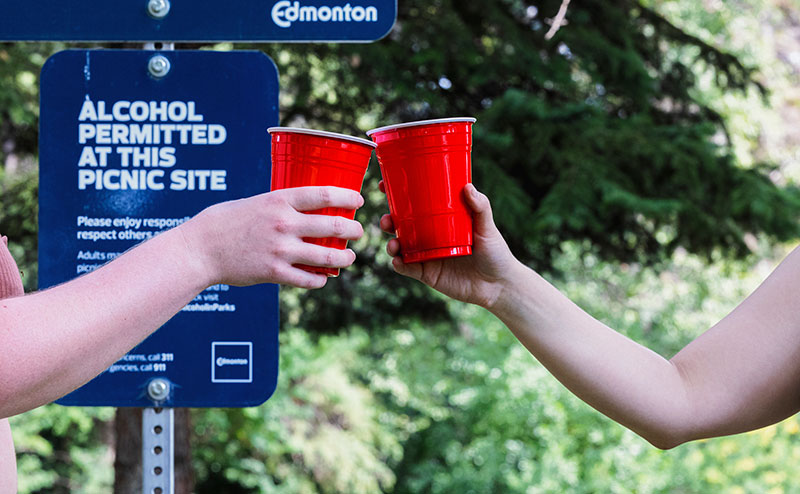 two persons hitting cups together