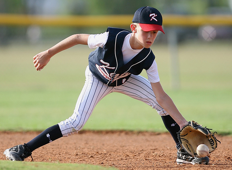 Young player catching a grounder ball