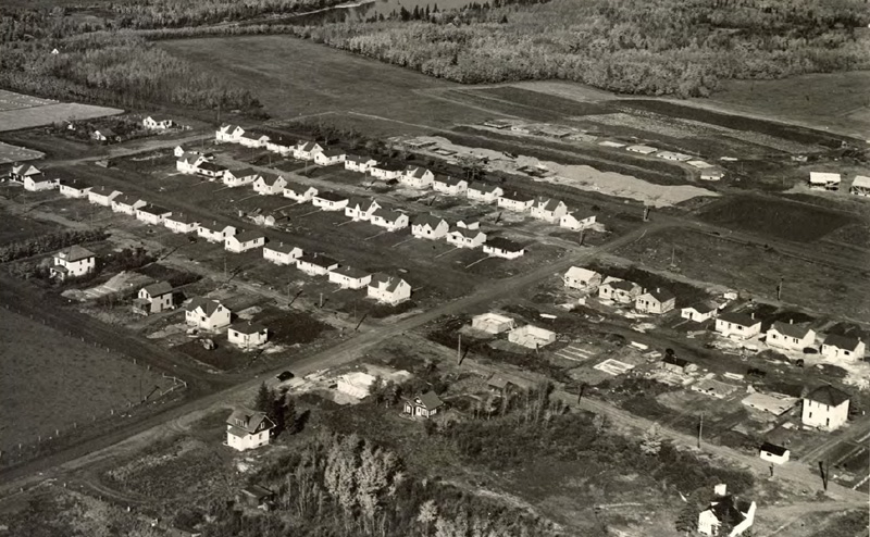 Black and white aerial photo of a housing development.