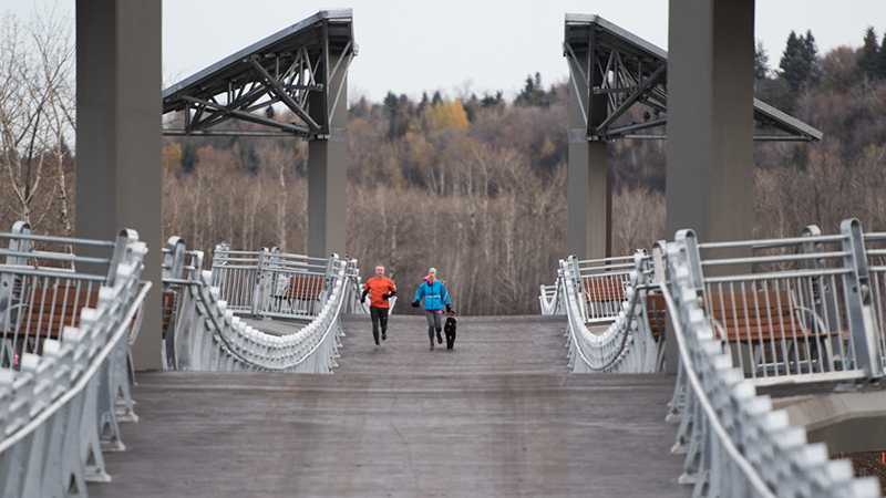 Runners with a dog crossing the bridge