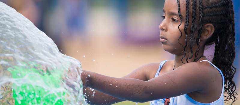 Young girl playing at a spray park