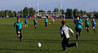 Two teams playing soccer outdoors.
