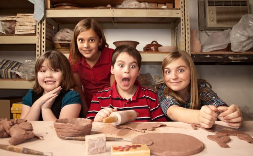 Four kids working on a clay project.