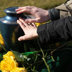 hand on urn with flower