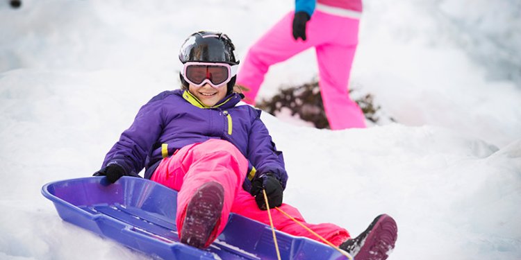 girl in helmet tobogganing
