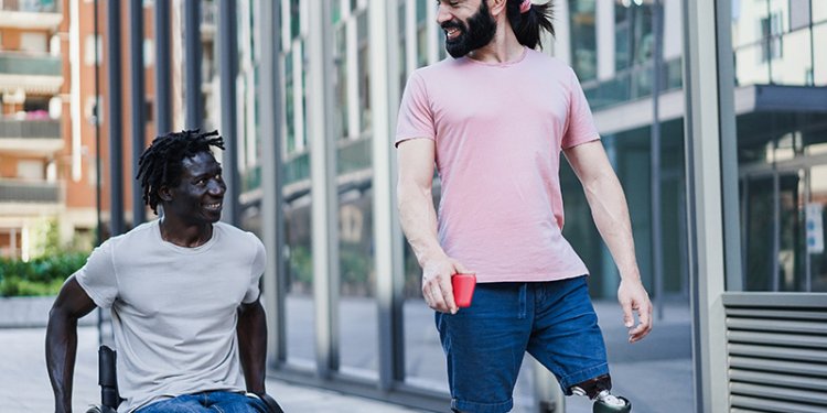 person of diverse abilities using crayon with attendant