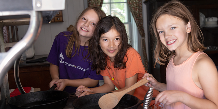 kids in John Walter museum using traditional wood stove