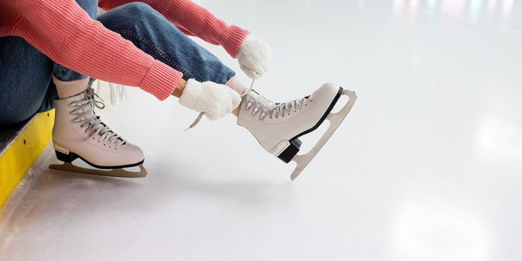 Young person lacing up ice skates