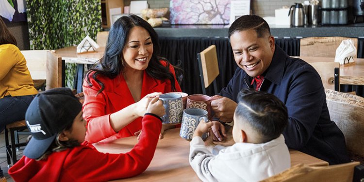 family sitting at table with cups in hands