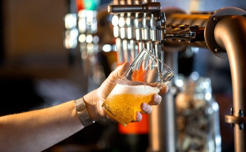 hand pouring a pint in the bar