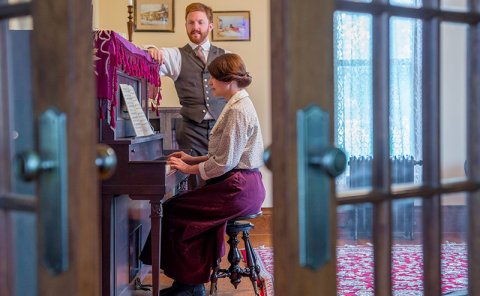 people in historical house at piano