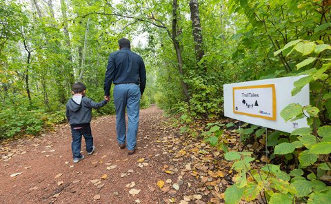 father walking with son in park trail