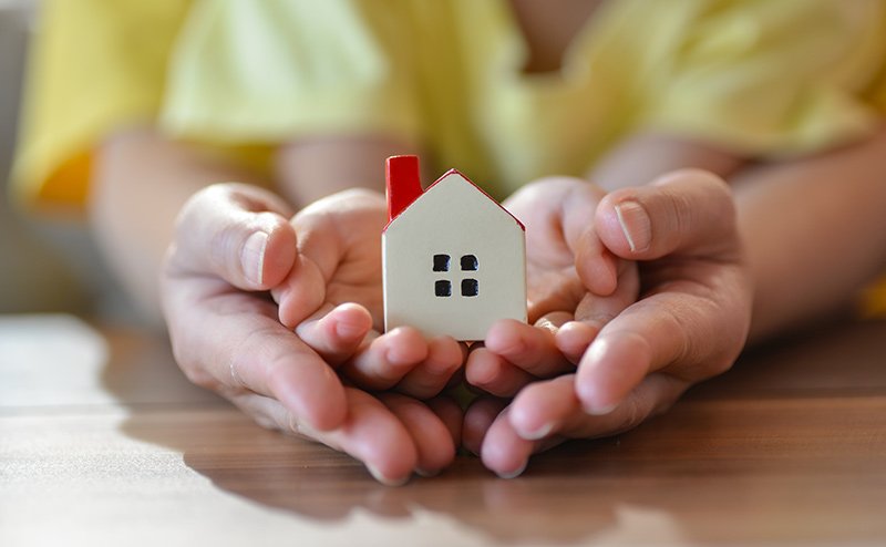 child's hand holding house