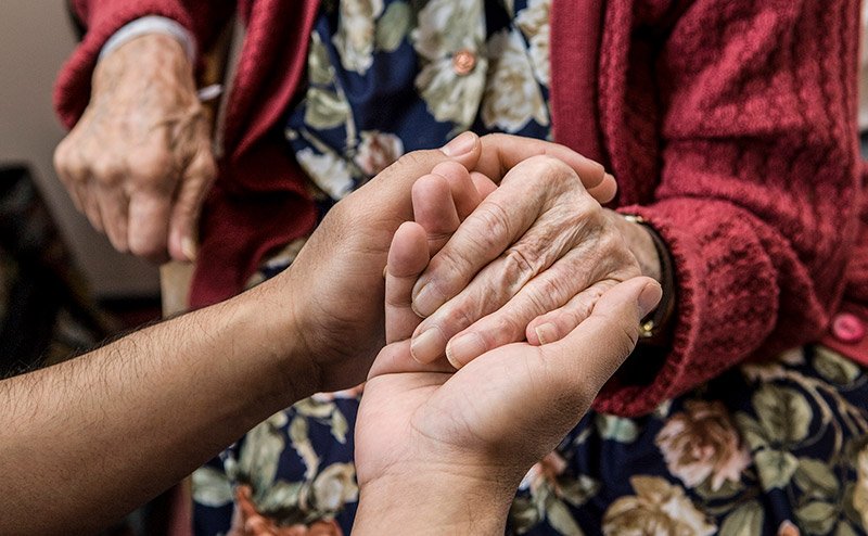 person holding senior's hand