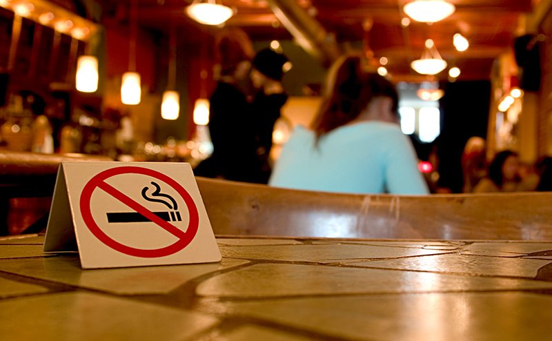no smoking on premises sign on bar table
