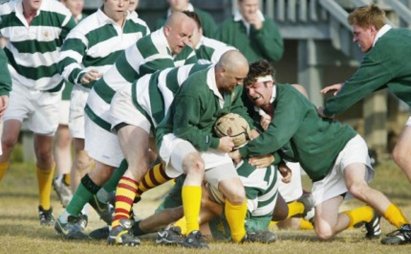 Group of people tackling a rugby player