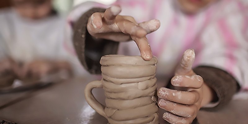 Child making a pottery mug